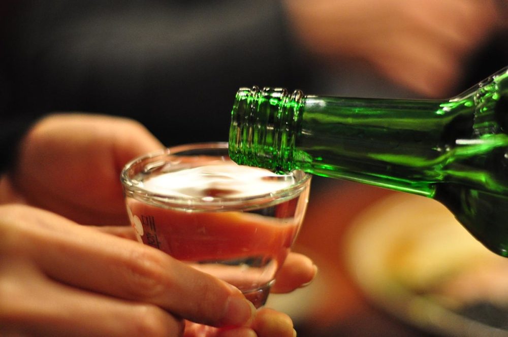 Pouring Soju into a glass as part of Korean table manners