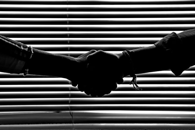 two people shaking hands in monochrome
