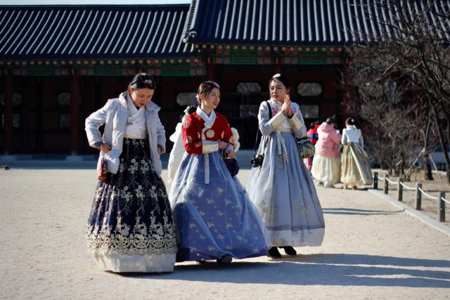 Korean women wearing traditional hanbok while walking in palace garden