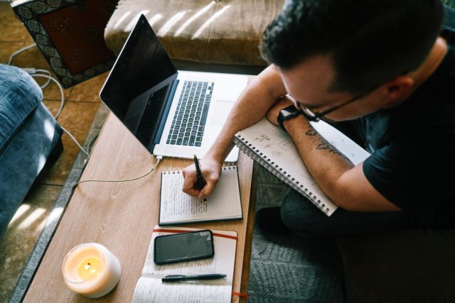 man writing notes and beeing creative to achieve a powerful linkedin profile