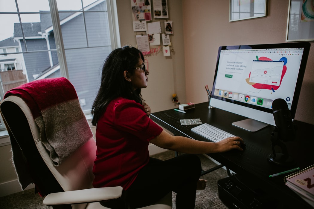 Woman working on a laptop from home during covid.