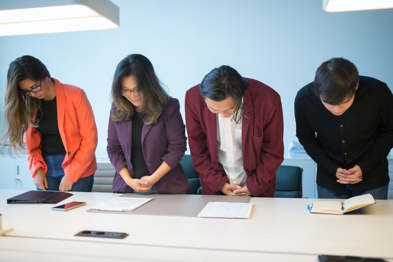 A group of business professionals demonstrating Japanese manners by bowing.