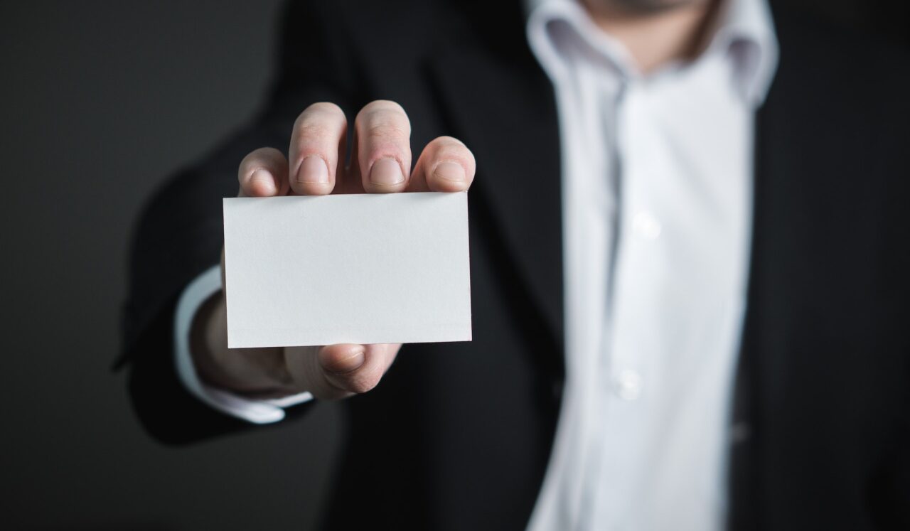 A guy in a business suit presenting a business card.