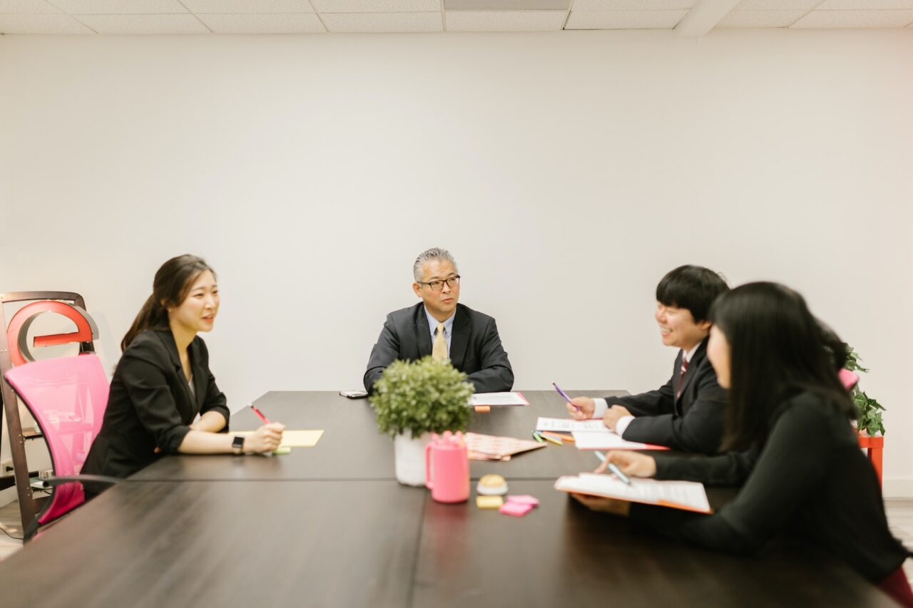 A group of Japanese business professionals discussing business at a table.